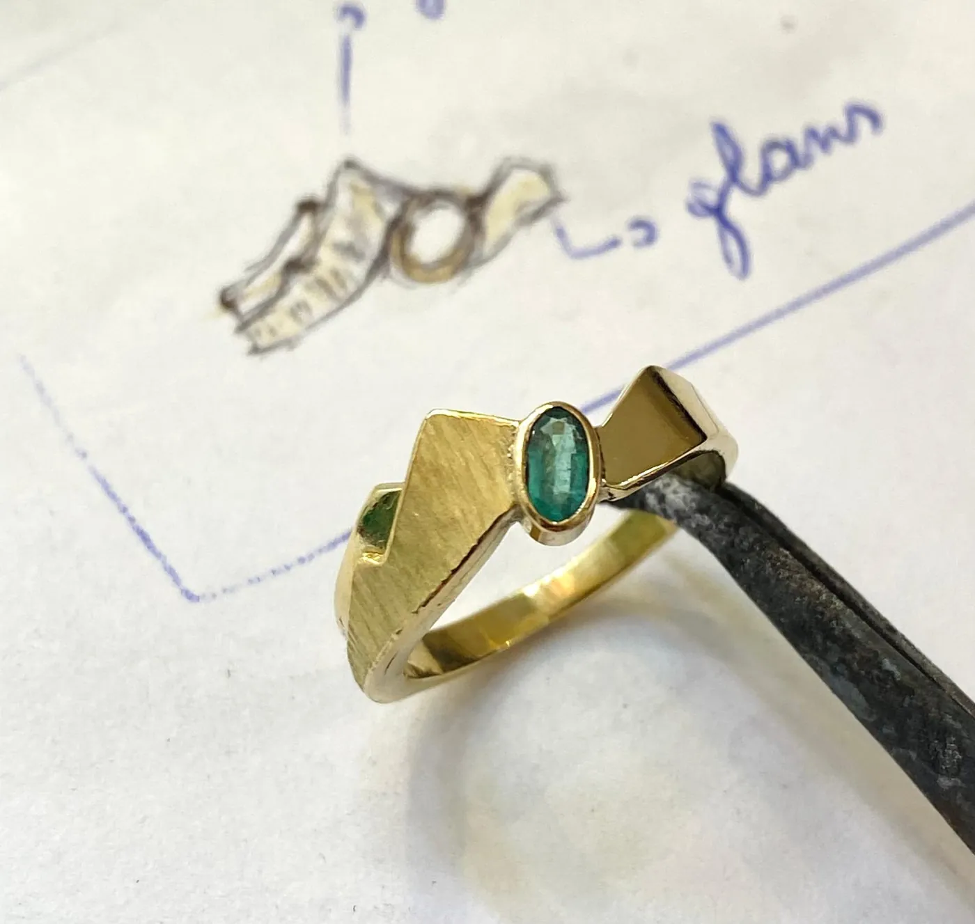 Gouden ring met groene steen op de ontwerpschets